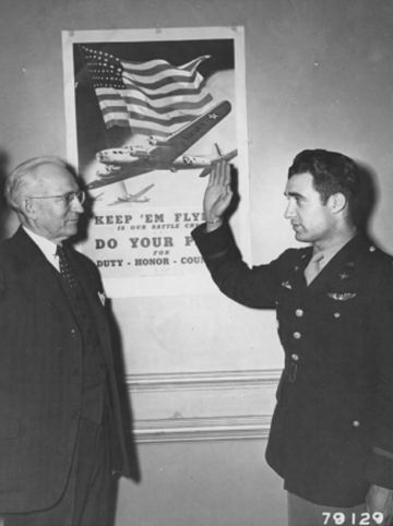 Henry B. Hazard, designated representative of the Immigration and Naturalization Service, swears in Lt. Steve Pissanos, Plainfield, N.J. as a citizen of the United States in London, England. Lt Pissanos was the first person to receive citizenship in the European Theatre of Operations (May 3, 1943).